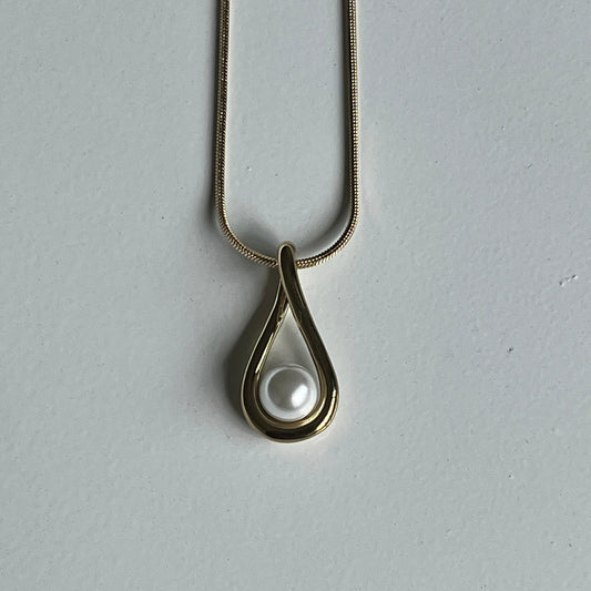 Necklace with a pearl pendant on a gray background